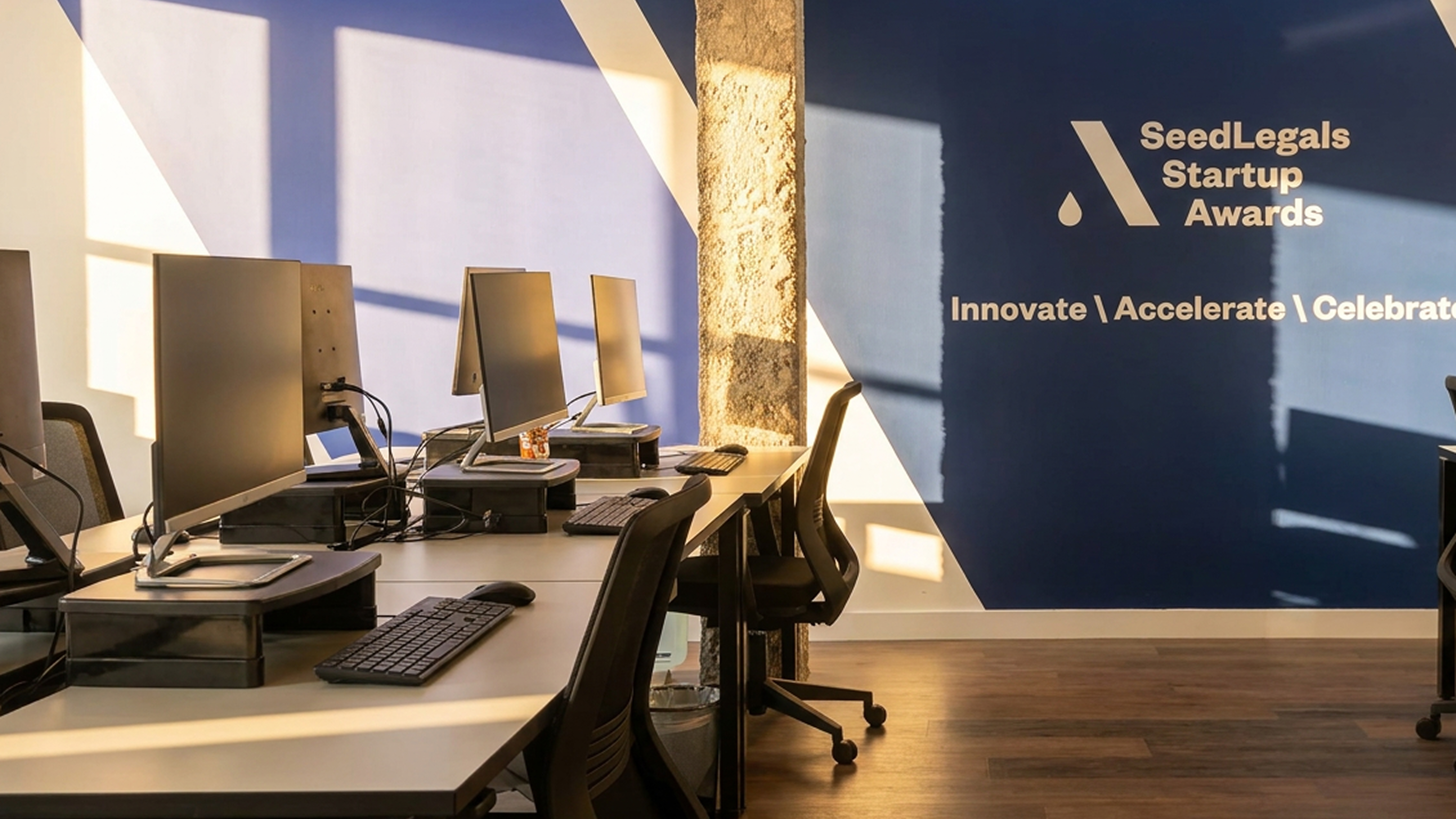 The SeedLegals office, with a Startup Awards branded wall behind a row of desks