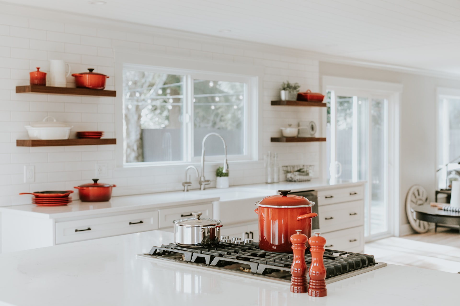 A styled kitchen scene with red Le Creuset cookware