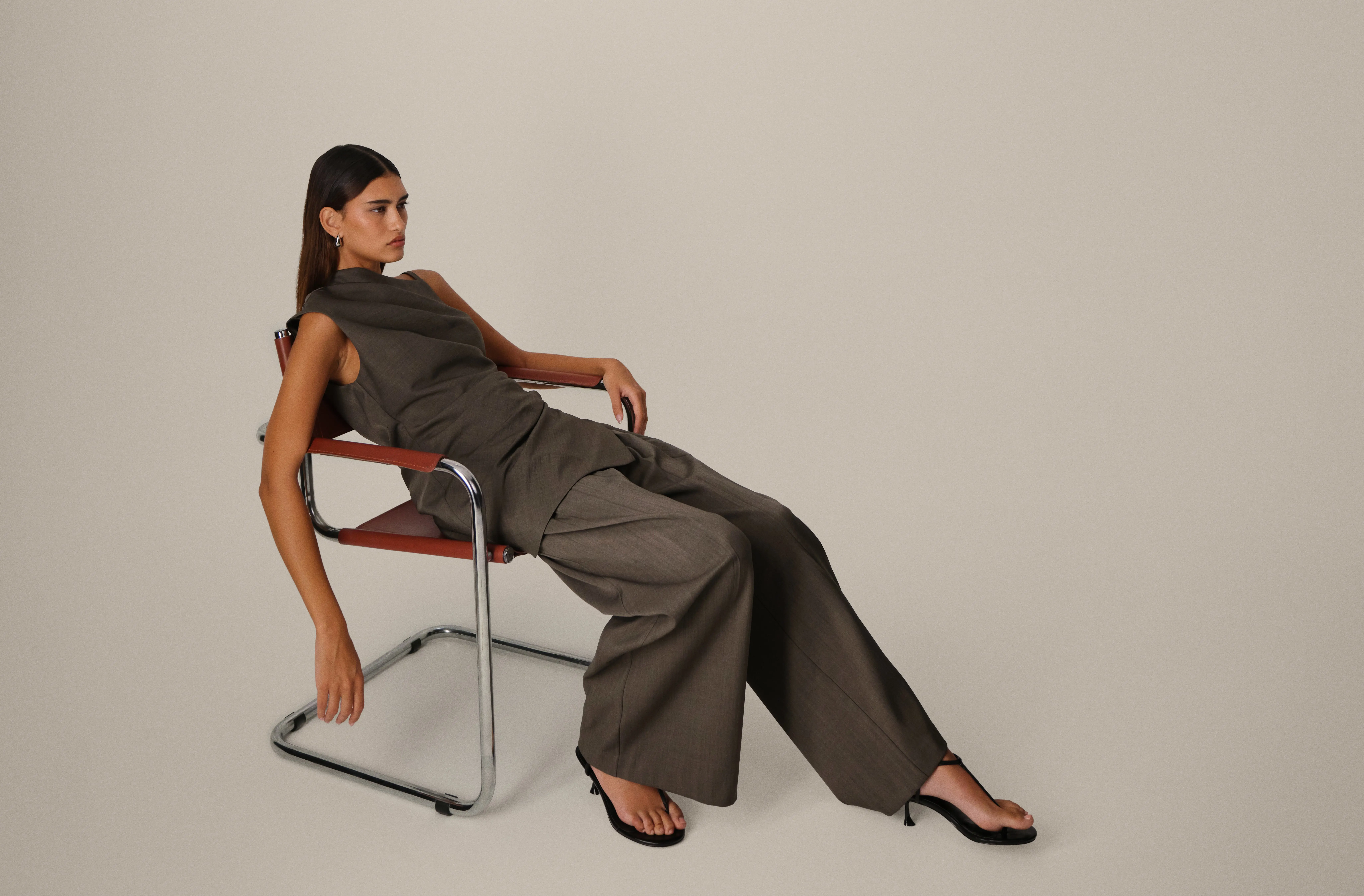 A model in a tailored co-ord sitting in a chair, shot in an ASOS-style editorial fashion photo