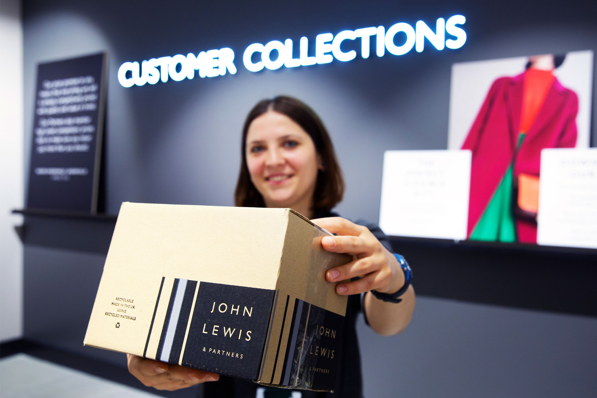 A John Lewis & Partners employee handing over a parcel at the Customer Collections point in store